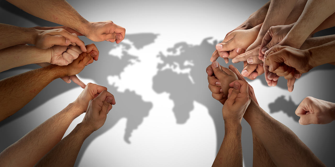 Hands joined around a map of the world